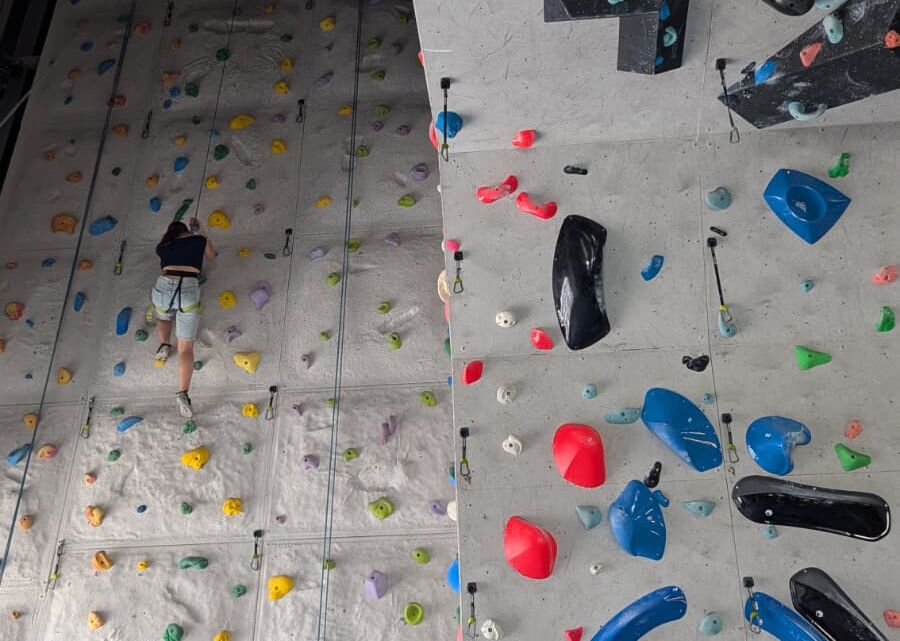 Eine Jugendliche klettert in der Halle