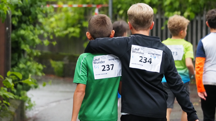 Kinder stützen sich gegenseitig und gehen ein Stück gemeinsam