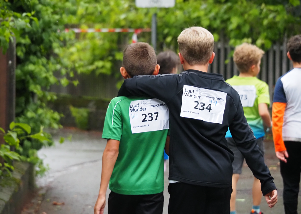 Kinder stützen sich gegenseitig und gehen ein Stück gemeinsam